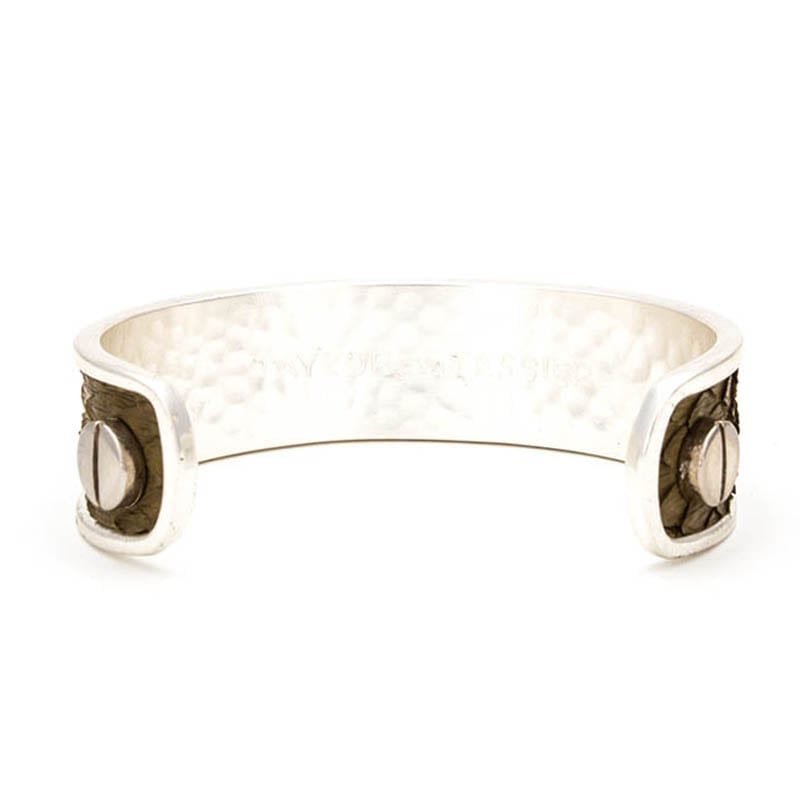 A small silver cuff to demonstrate the type of jewelry used in sterling silver care.