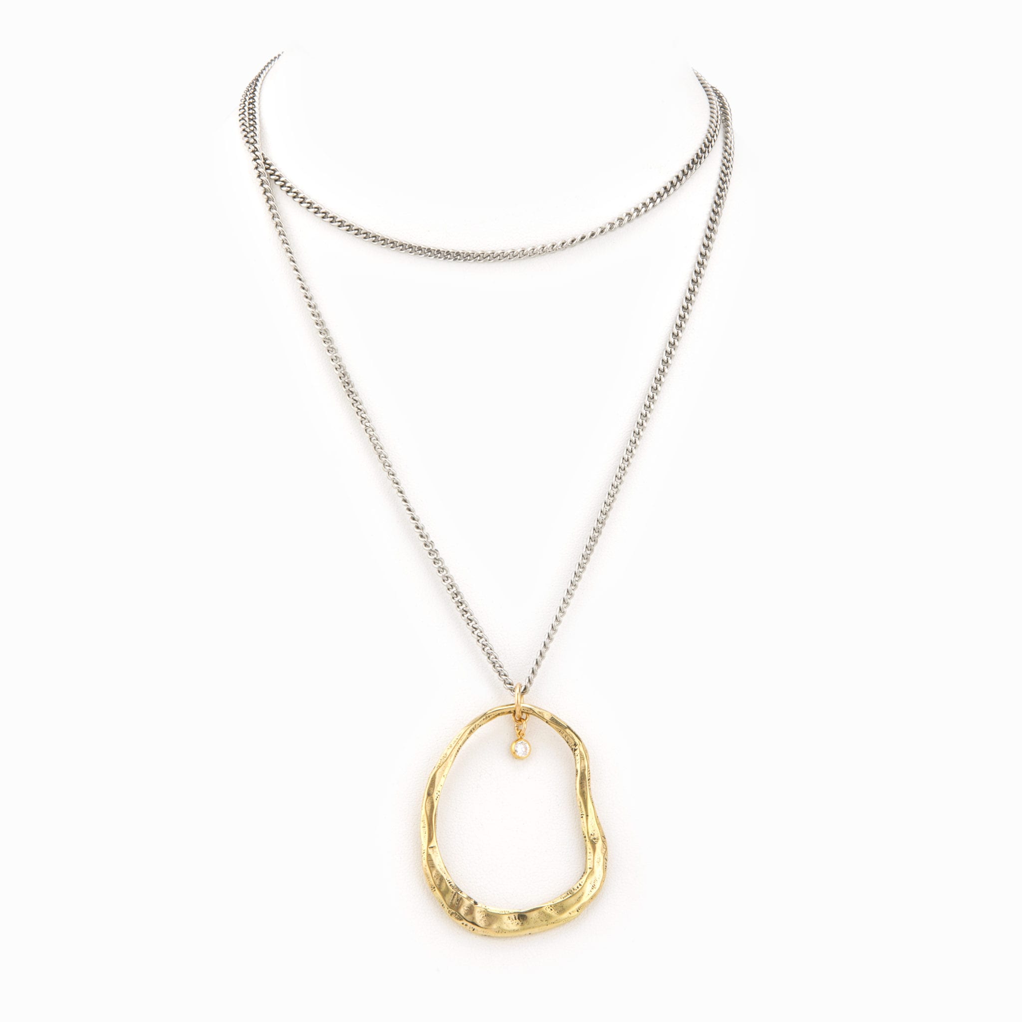 Flat silver chain necklace with gold organic circle charm and crystal detail.