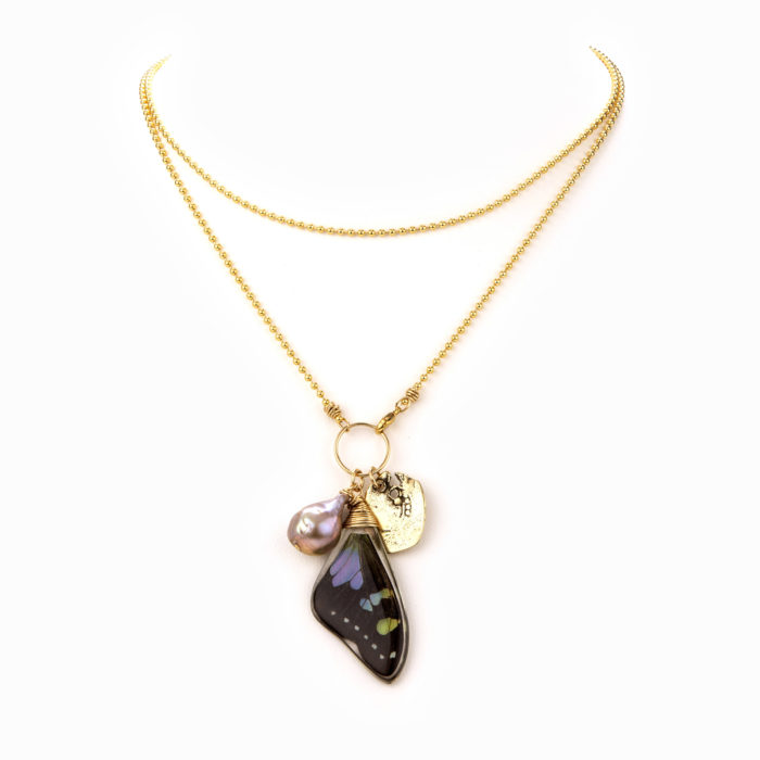 A delicate and thin gold ball chain with multi-colored butterflywing charm.