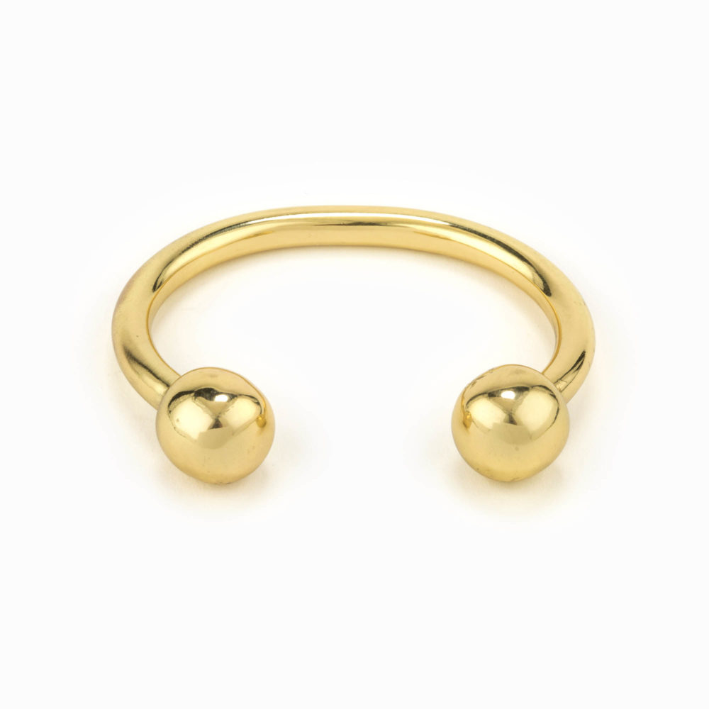 A solid adjustable brass cuff with ball detail.