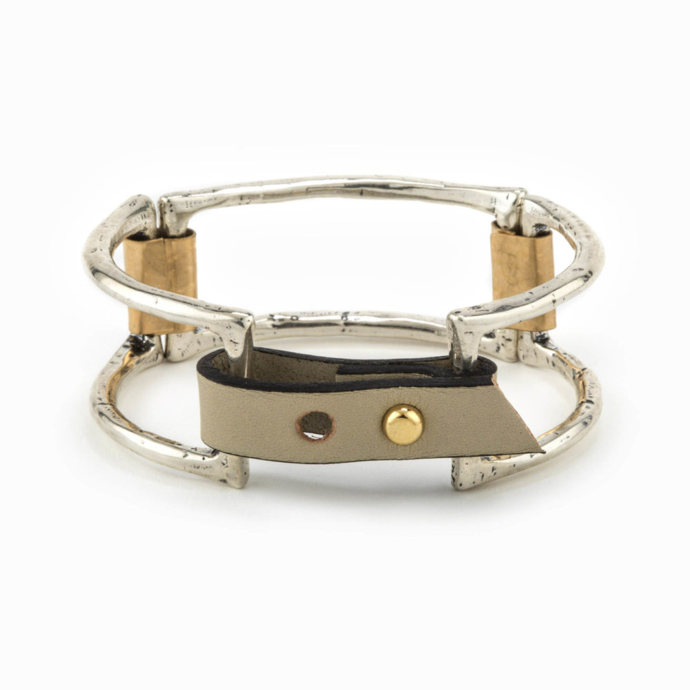 A rhodium casted cuff with large square pieces linked together with 14k gold fill plates and an adjustable leather closure.