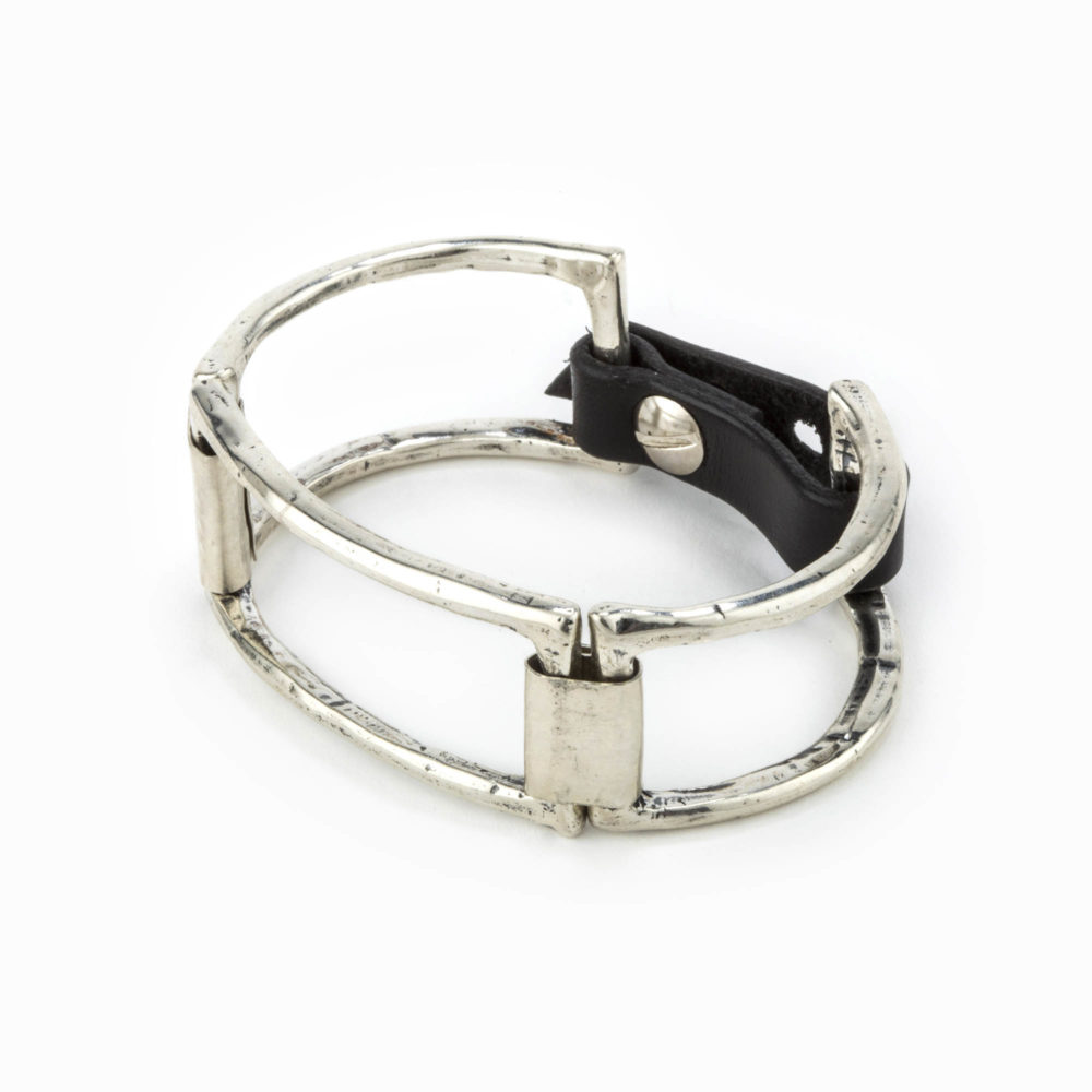 A rhodium casted cuff with large square pieces linked together with sterling silver plates and an adjustable leather closure.