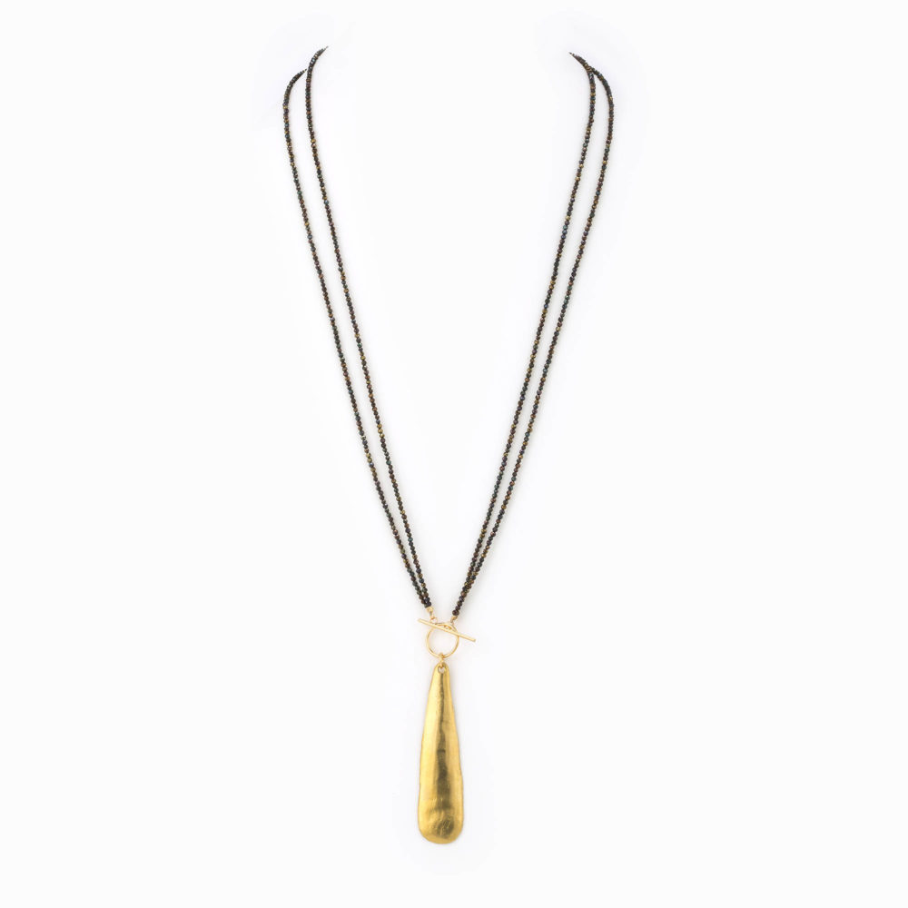 A multilayered black metallic spinel beaded necklace with 14k gold-filled clasp and large brass teardrop charm.