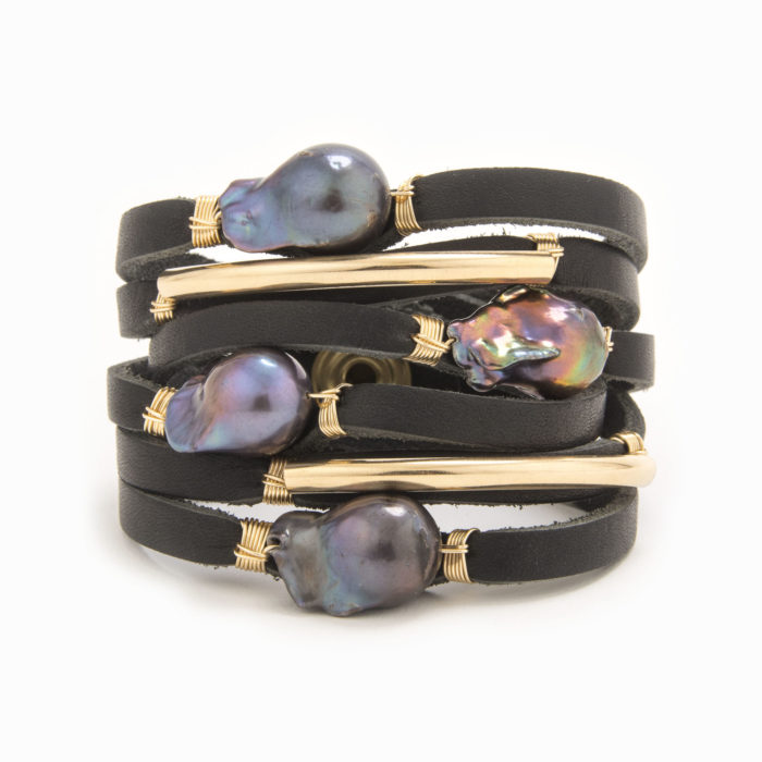 A black-colored leather wrap bracelet with wire wrapped in 14k gold fill tubes with scattered black fresh water pearls.