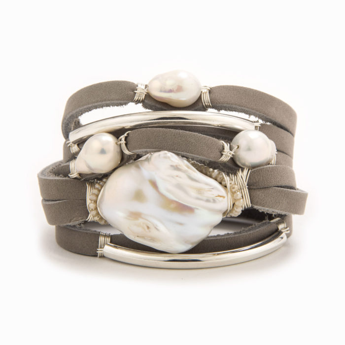 A light brown leather wrap bracelet with wire wrapped in sterling silver tubes with scattered baroque and fresh water pearls.