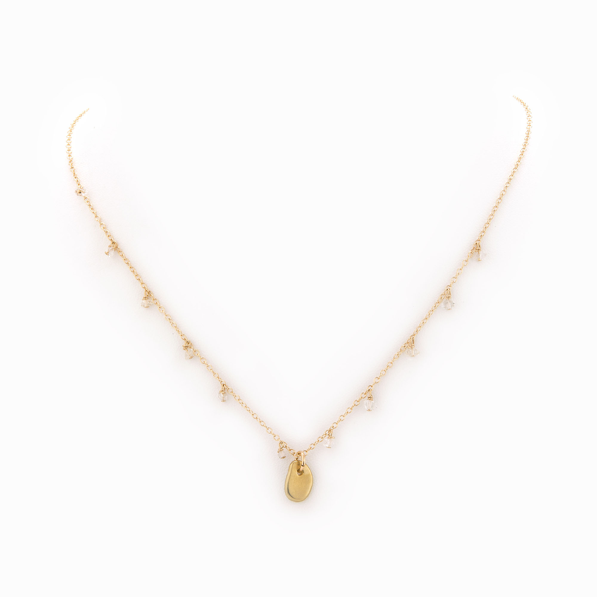 A 14k gold-filled chain necklace with a brass pebble and Herkimer quartz pieces.