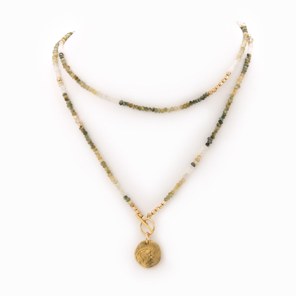 A layered necklace of graduated moss agate, moonstone and 14k gold-filled beads with an antique brass coin charm.