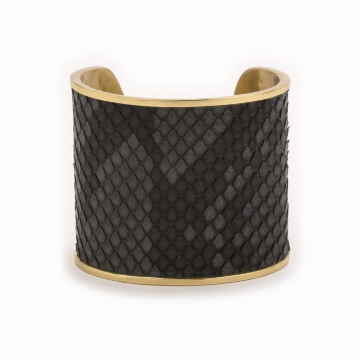 Front view of a large gold cuff with charcoal colored snakeskin pattern inlaid.