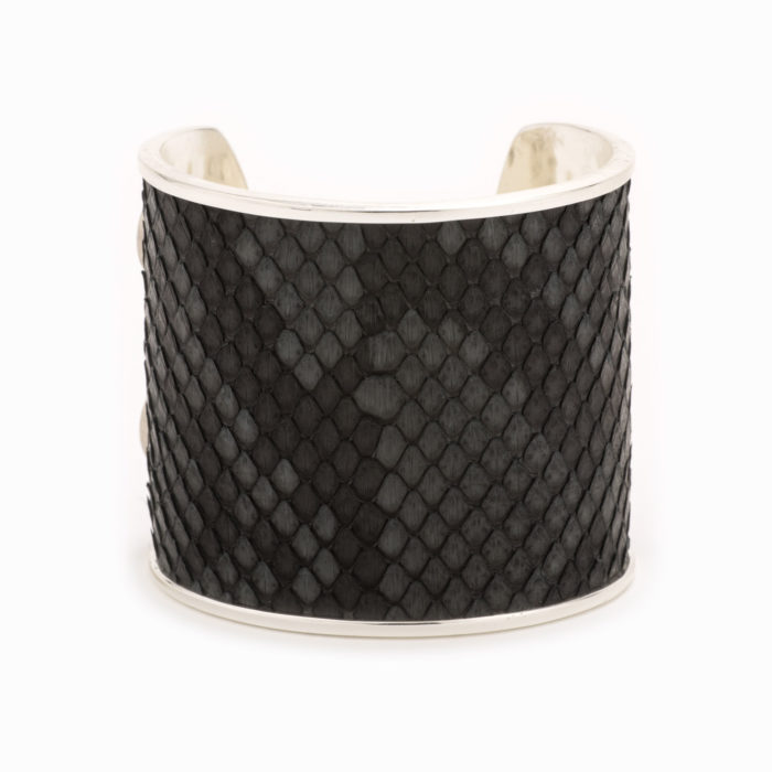 Front view of a large silver cuff with charcoal colored snakeskin pattern inlaid.