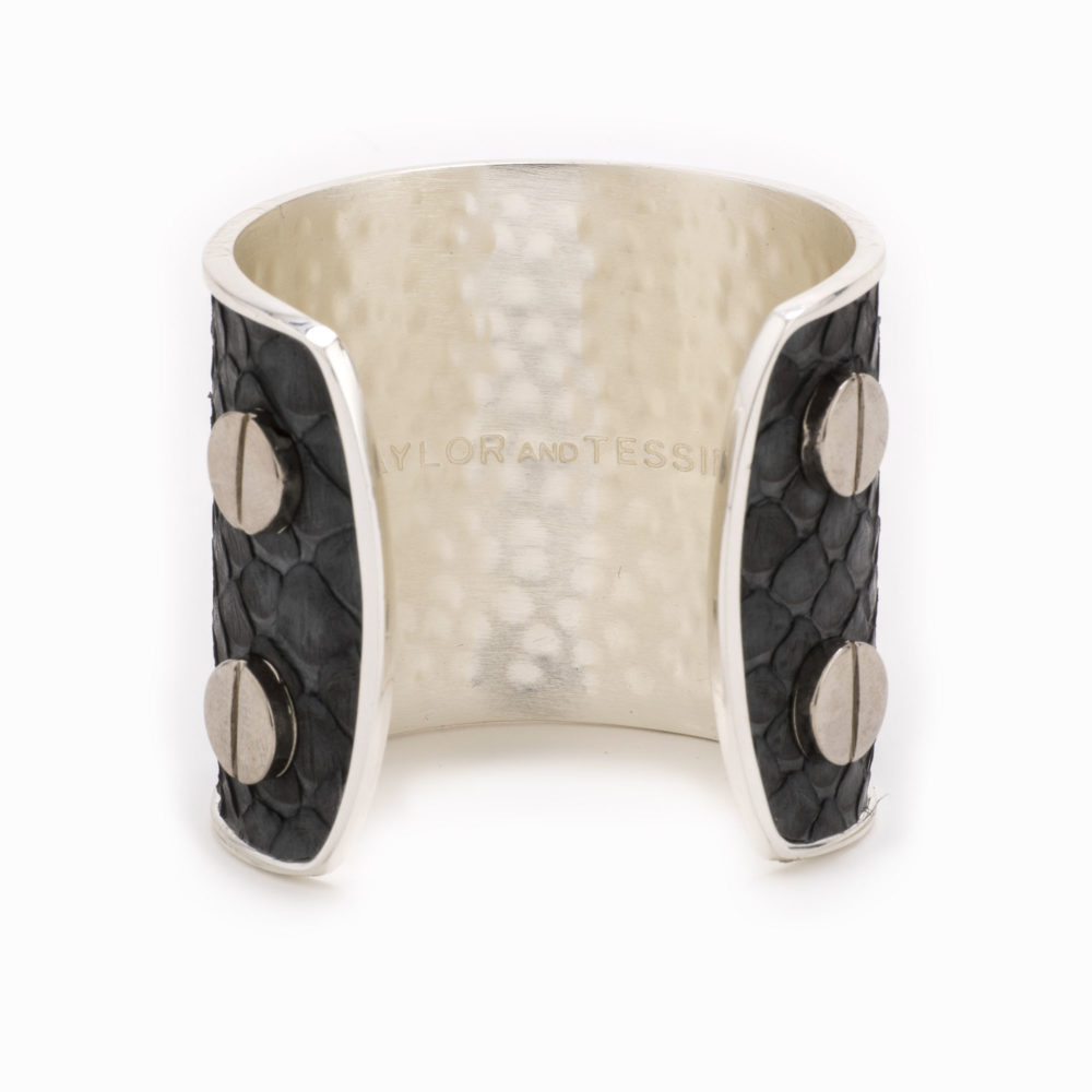 Rearview of a large silver cuff with charcoal colored snakeskin pattern inlaid.