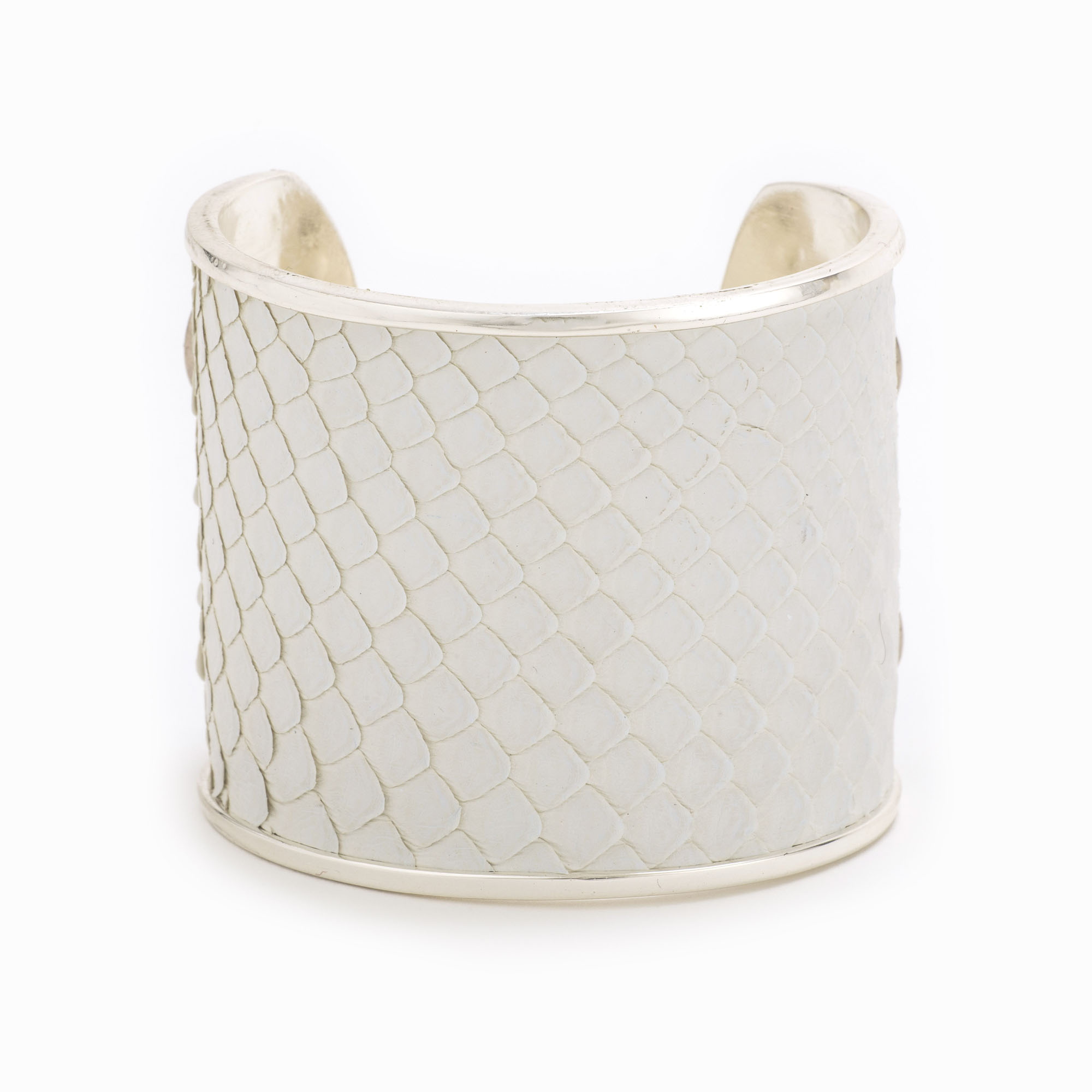 A large silver cuff with white colored snakeskin pattern inlaid.