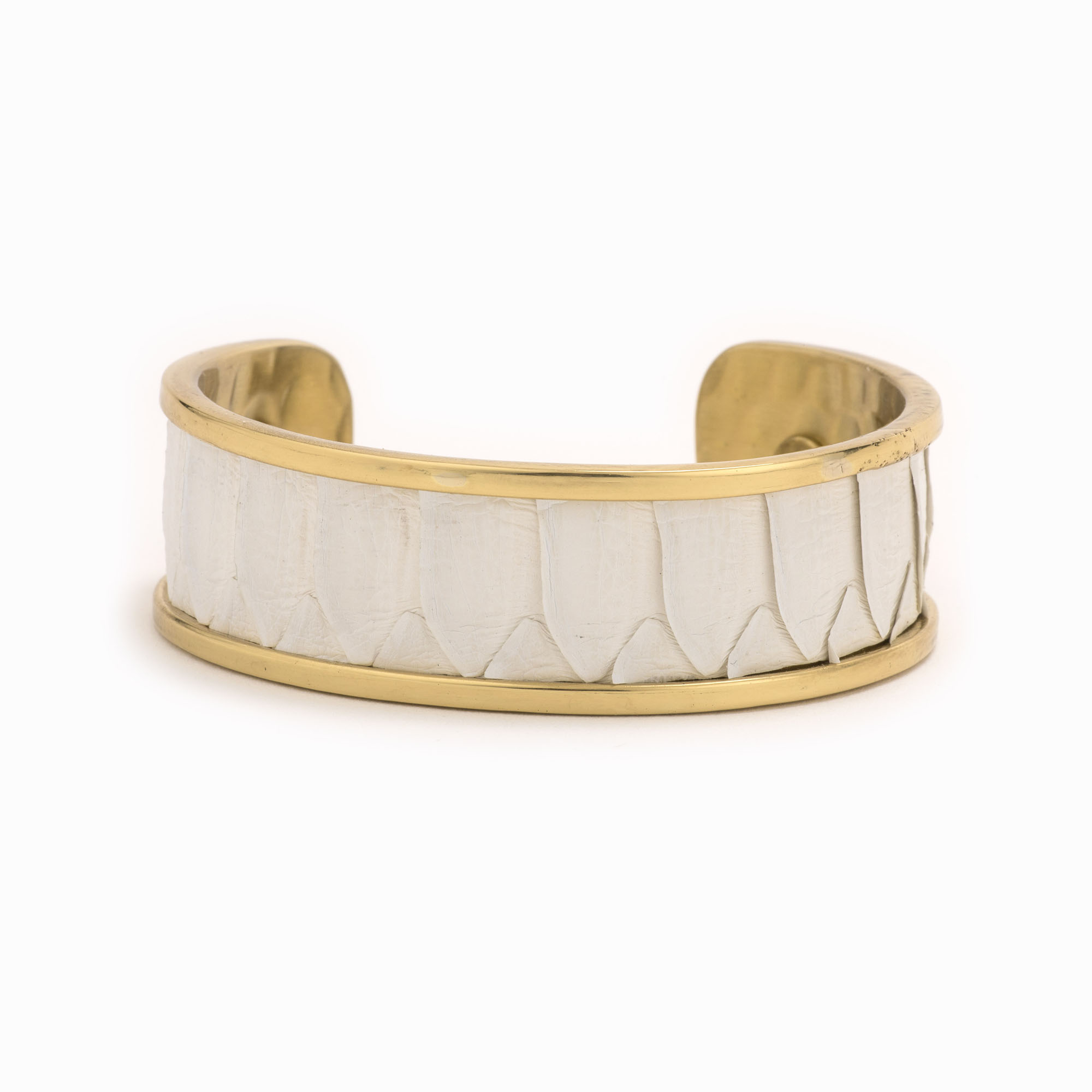 A medium gold cuff with white colored snakeskin pattern inlaid.