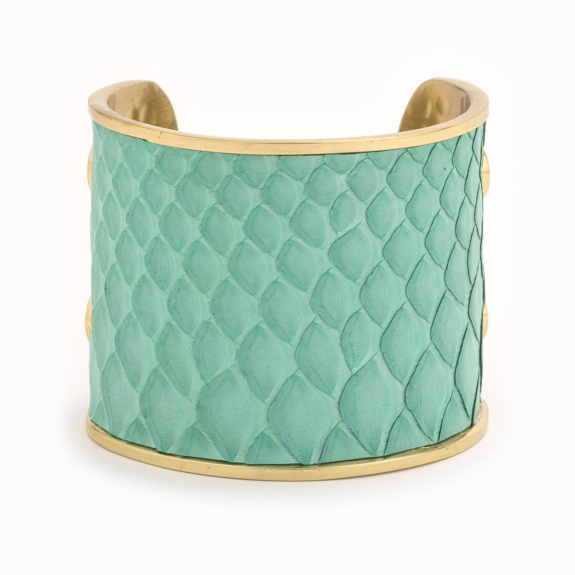 A large gold cuff with turquoise colored snakeskin pattern inlaid.