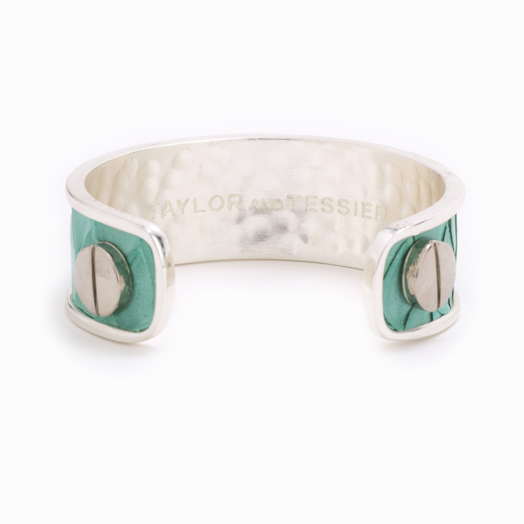 A medium silver cuff with turquoise colored snakeskin pattern inlaid.