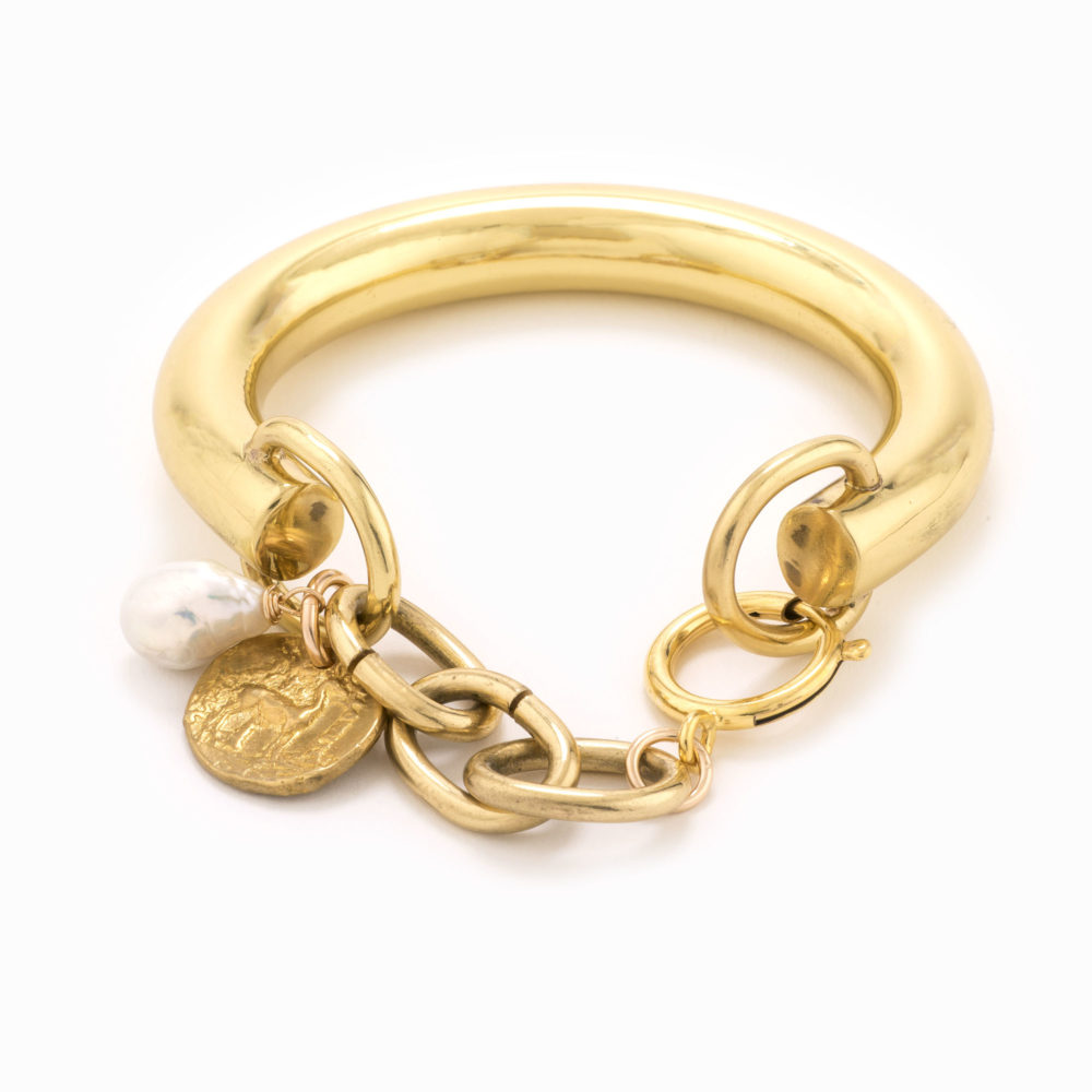 A solid brass bracelet with a coin, pearl and adjustable closure.