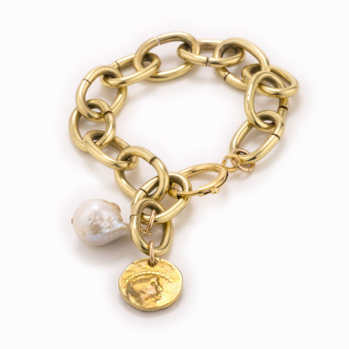 An adjustable, large brass chain bracelet with coin and white pearl.