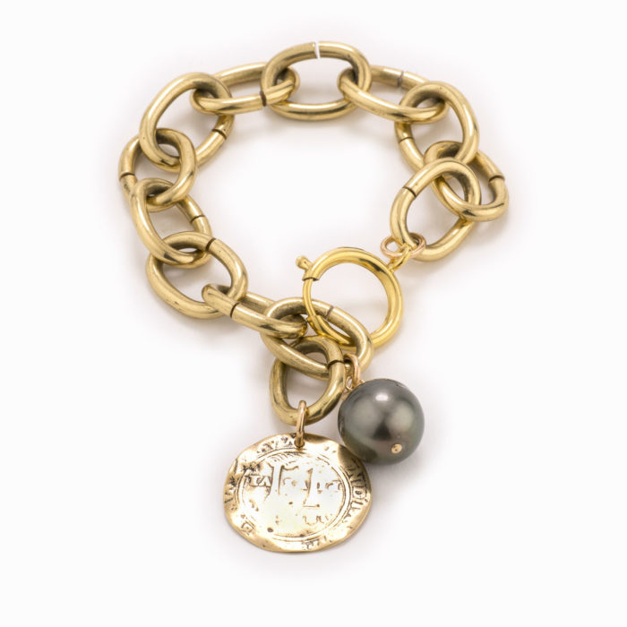 An adjustable, large brass chain bracelet with coin and black pearl.