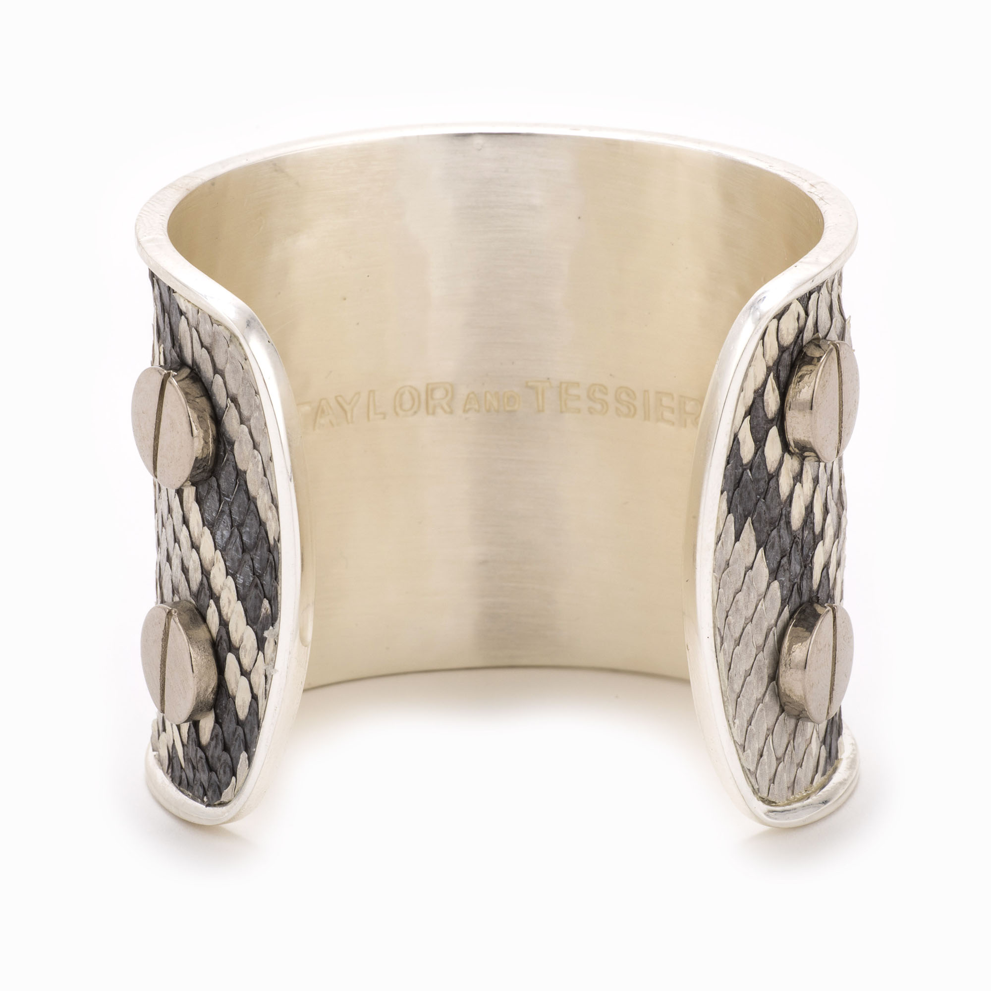 A large silver cuff with black and white colored snakeskin pattern inlaid.