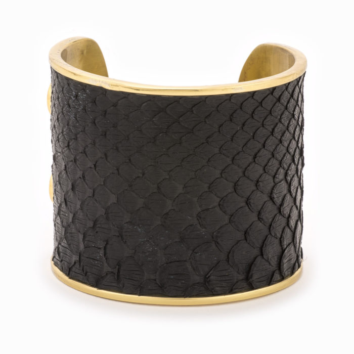 A large gold cuff with black colored snakeskin pattern inlaid.