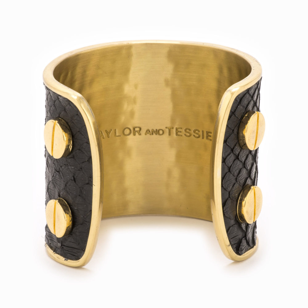 A large gold cuff with black colored snakeskin pattern inlaid.