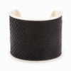 A large silver cuff with black snakeskin pattern inlay.