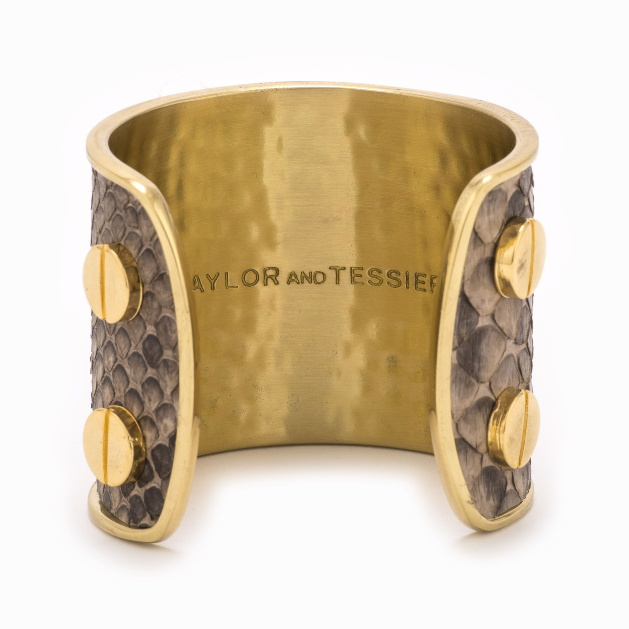 A large gold cuff with grey and brown colored snakeskin pattern inlaid.