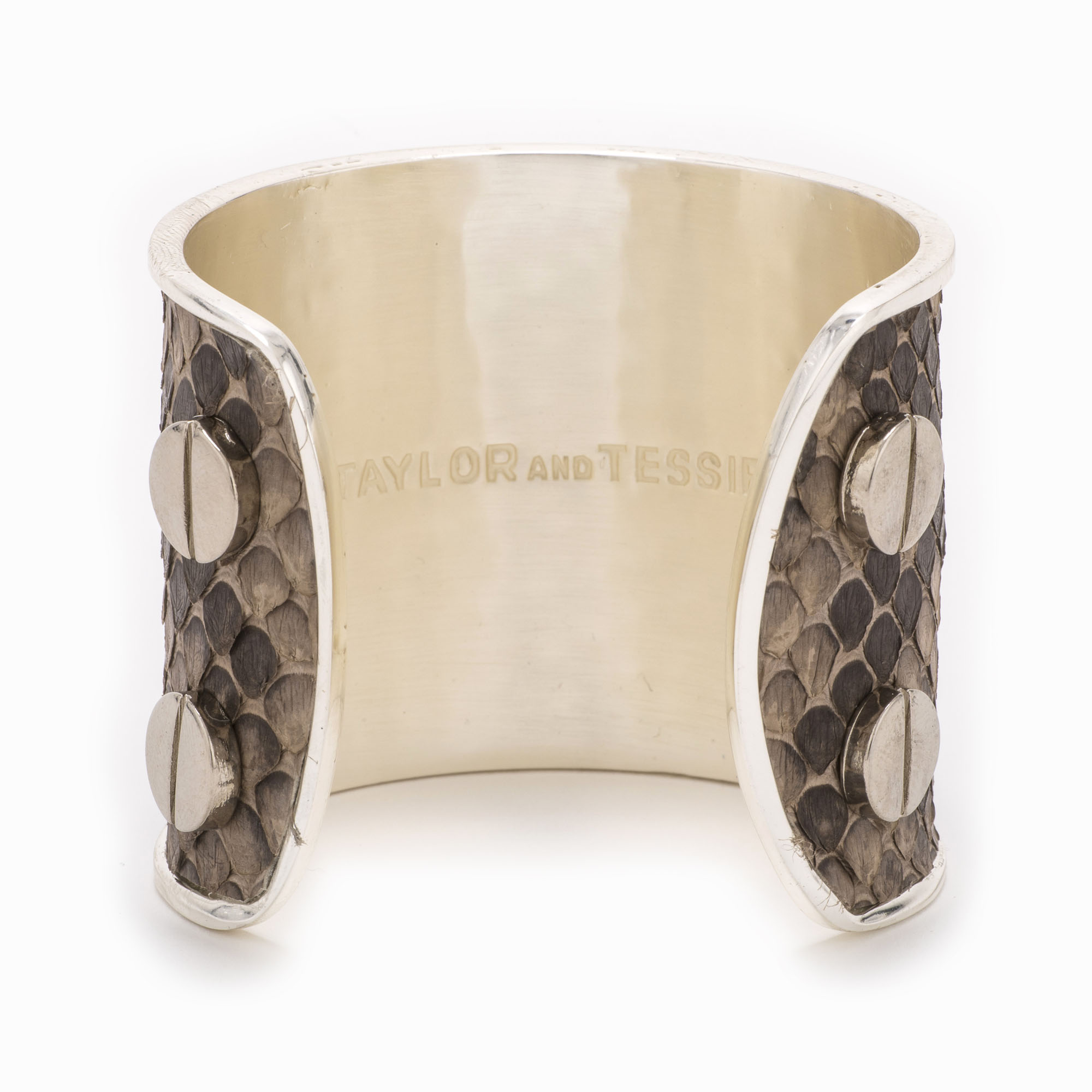 Rear view of a large silver cuff with grey and brown colored snakeskin pattern inlaid.