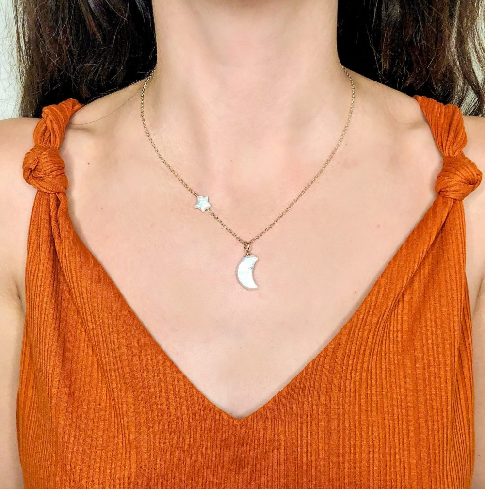 A delicate necklace with 14k gold-filled chain with a white pearl star and moon charm.