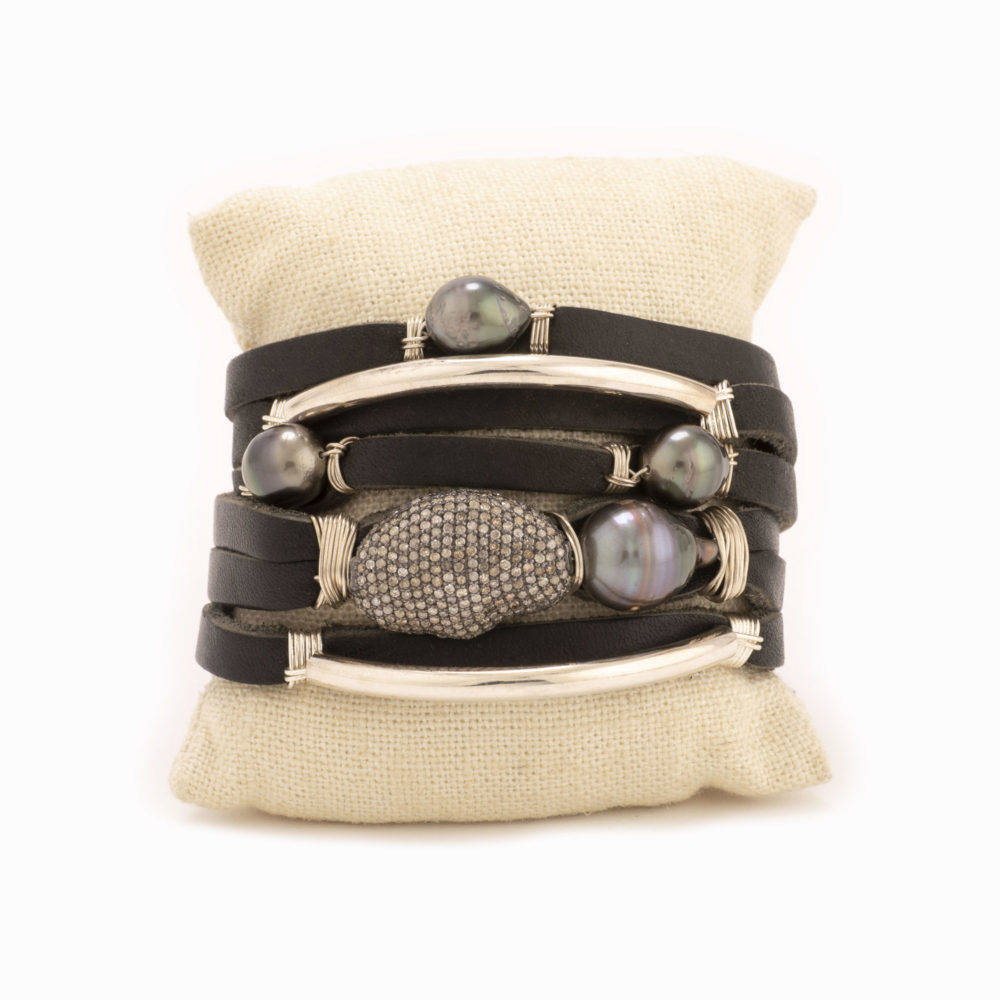 A shred style bracelet with black leather, Tahitian pearls, diamond nugget, and sterling silver detail.