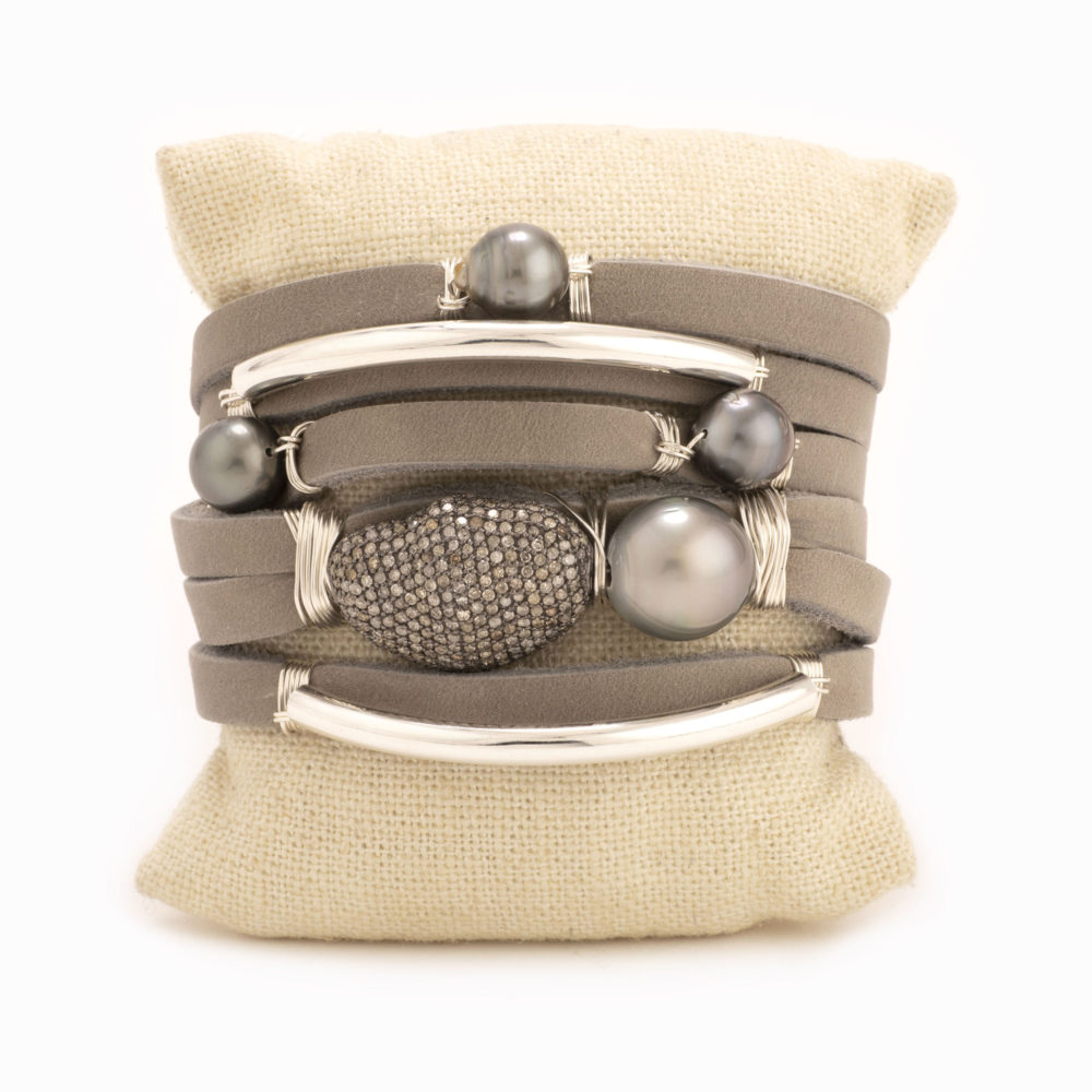 A shred style bracelet with taupe leather, Tahitian pearls, diamond nugget, and sterling silver detail.