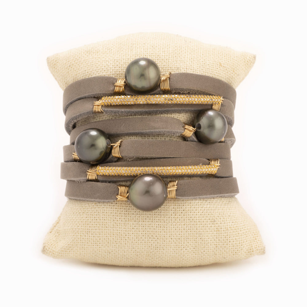 A taupe leather shred bracelet with 18k gold diamond detail and Tahitian pearls.