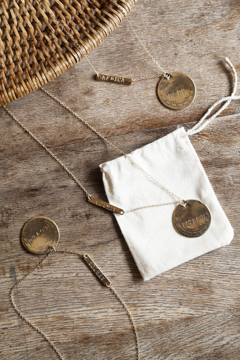 3 gold chain necklaces laying across a wooden table.