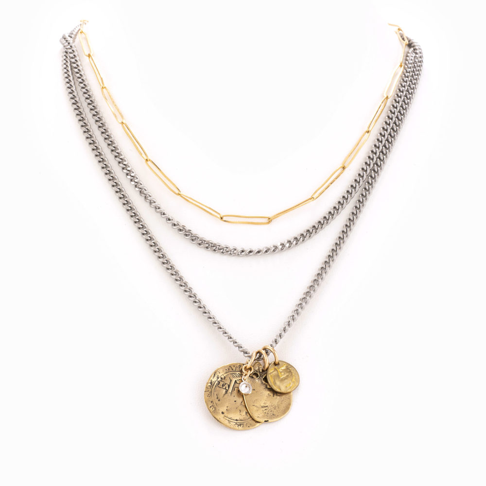A multi-layered mixed metal chain necklace completed with multiple antique brass coins and a bezel.